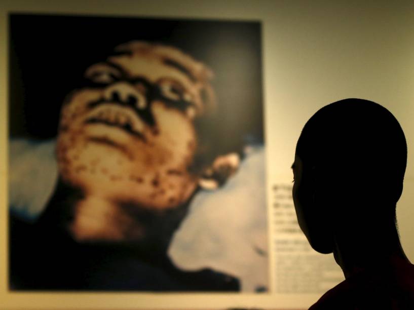 Estudante japones observa a fotografia de um soldado com manchas de sangramento interno devido ao ataque que atingiu Hiroshima, no Museu Memorial da Paz de Hiroshima, na véspera do aniversário de 70 anos do ataque responsável pela morte de 140 mil pessoas