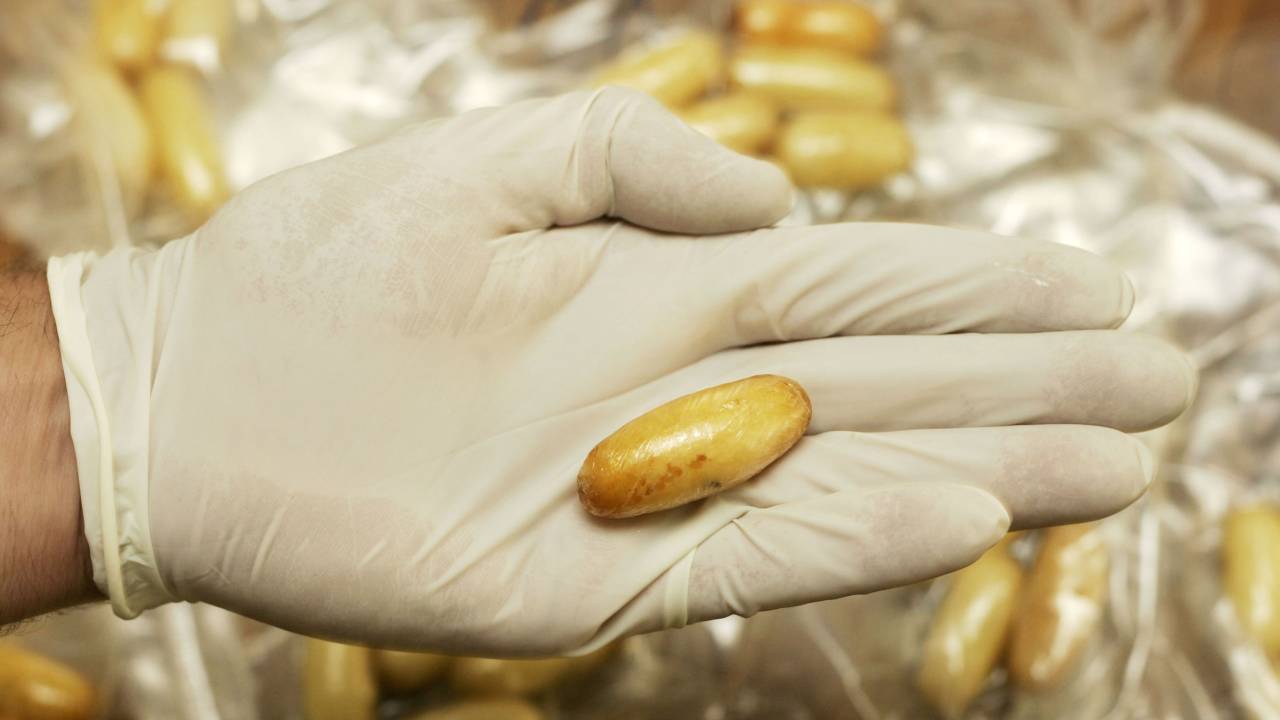 Policial mostra pílula com cocaína ingerida por 'mulas'