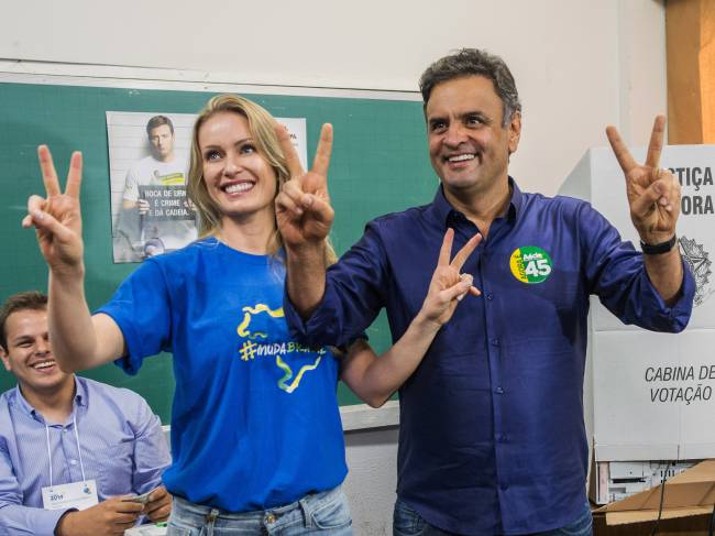 O candidato à Presidência pelo PSDB, Aécio Neves, durante votação na Escola Estadual Governador Milton Campos (Estadual Central), no bairro de Lourdes, em Belo Horizonte (MG), neste domingo (26). Sua mulher, Letícia Weber, o acompanha