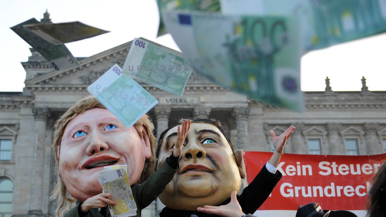 Em Berlim, ativistas jogam notas falsas de euro em protesto contra os planos de aumento no orçamento do serviço de inteligência alemão