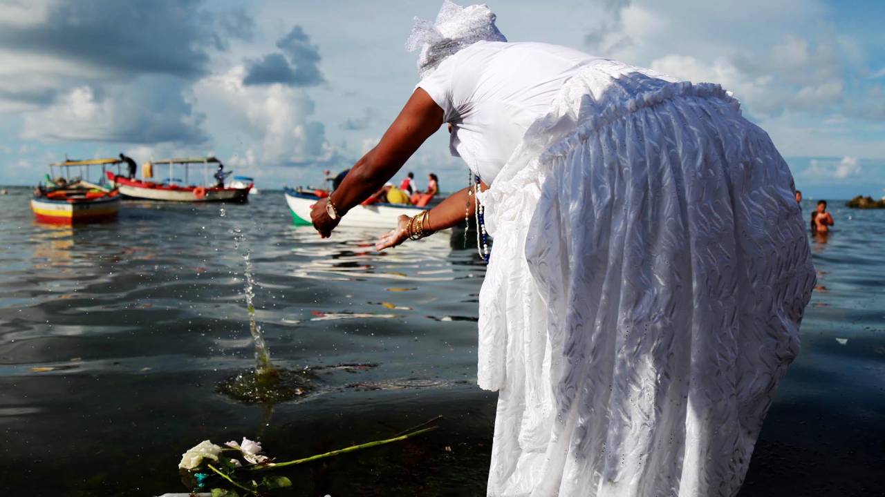 Mulher joga oferenda e rosas para Iemanjá no bairro Rio Vermelho, em Salvador. Cerca de 700 mil pessoas prestigiam o dia da orixá considerada 'rainha do mar' pela tradição do Candomblé