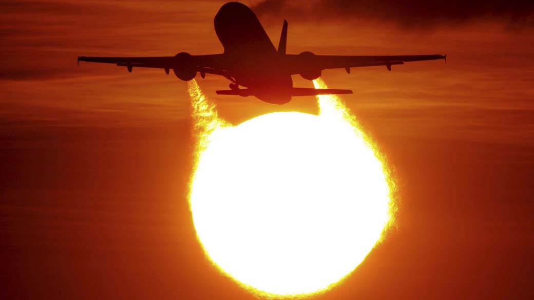 Avião decola durante o pôr do sol no aeroporto de Duesseldorf na Alemanha