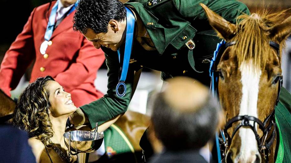 Competição de cavalos de Theo (Rodrigo Lombardi), que estende a taça para a Morena (Nanda Costa)