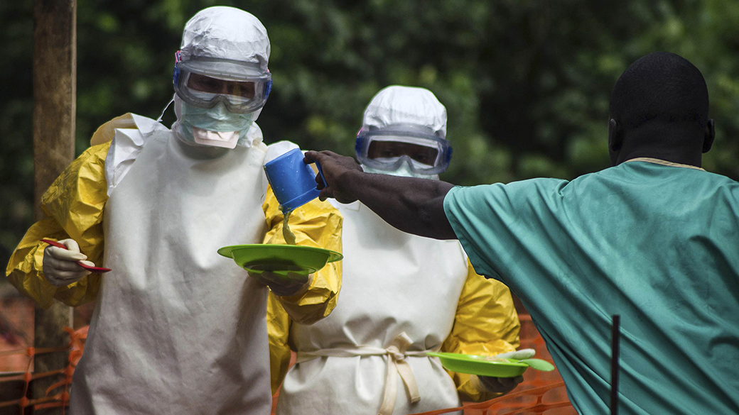 Equipe do 'Médicos Sem Fronteiras' entregam comida para os pacientes mantidos em uma área de isolamento no centro de tratamento do Ebola