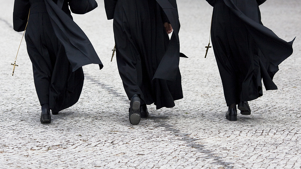 Em Portugual, três freiras caminham em direção ao Santuário de Fátima, durante peregrinação na cidade