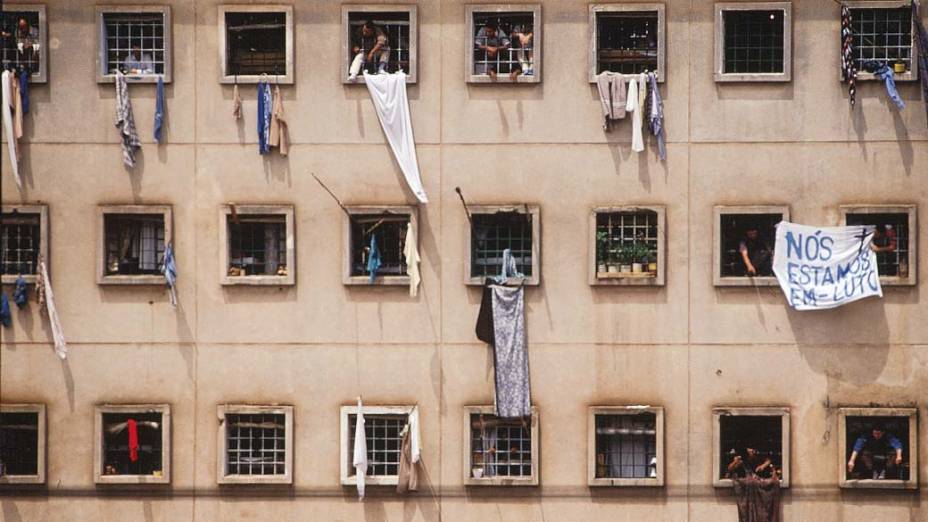 Presos nas janelas da Casa de Detenção de São Paulo, com faixa de protesto pela morte de 111 presos do Pavilhão 9, em 05/10/1992