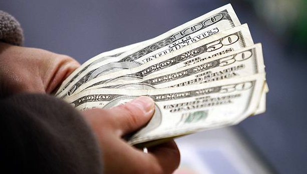 Pessoa contando notas de dólar