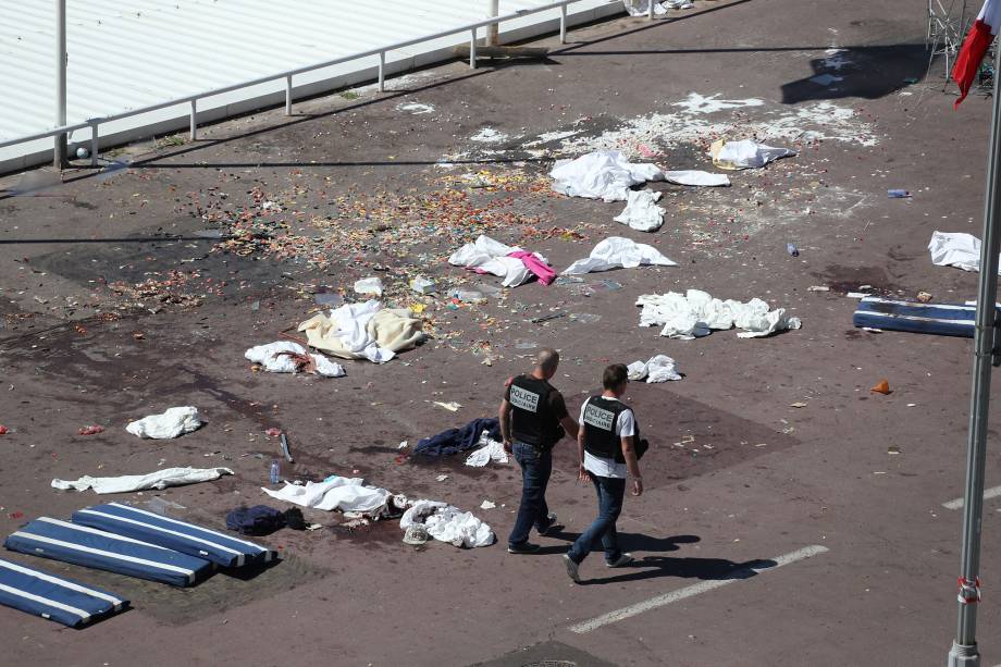 Policiais caminham no local do ataque com um caminhão que avançou contra a multidão que celebrava o Dia da Bastilha na cidade de Nice, na França - 15/07/2016