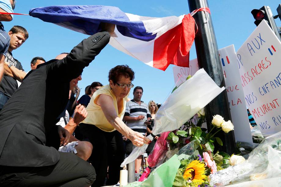 Mulher deixa flores e presta homenagem às vítimas do ataque terrorista em Nice, na França - 15/07/2016