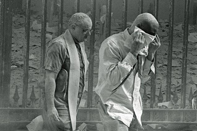 Homens cobertos de poeira caminham próximos ao local do atentado terrorista ao World Trade Center Homens cobertos de poeira caminham próximos ao local do atentado terrorista ao World Trade Center