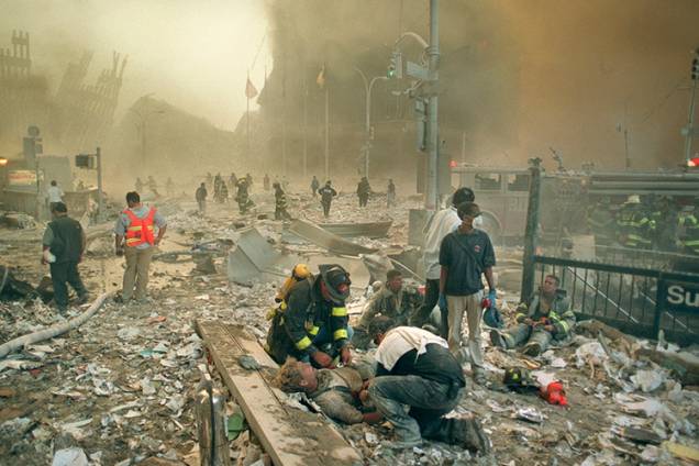 Bombeiros e paramédicos auxiliam feridos após os atentados terroristas ao World Trade Center Bombeiros e paramédicos auxiliam feridos após os atentados terroristas ao World Trade Center