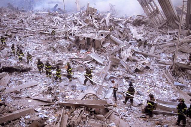 Bombeiros carregam mangueira entre as ruínas do World Trade Center Bombeiros carregam mangueira entre as ruínas do World Trade Center