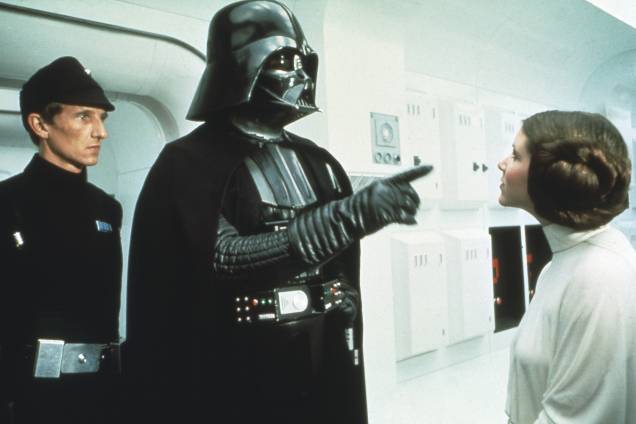 David Prowse, como Darth Vader, e Carrie Fisher no filme "Star Wars: Episósio IV - Uma Nova Esperança", de George Lucas. David Prowse, como Darth Vader, e Carrie Fisher no filme "Star Wars: Episósio IV - Uma Nova Esperança", de George Lucas.