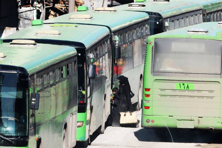 Pessoas entram em ônibus no distrito rebelde de Al-Sukkari, em Alepo, para serem evacuadas da região - 15/12/2016