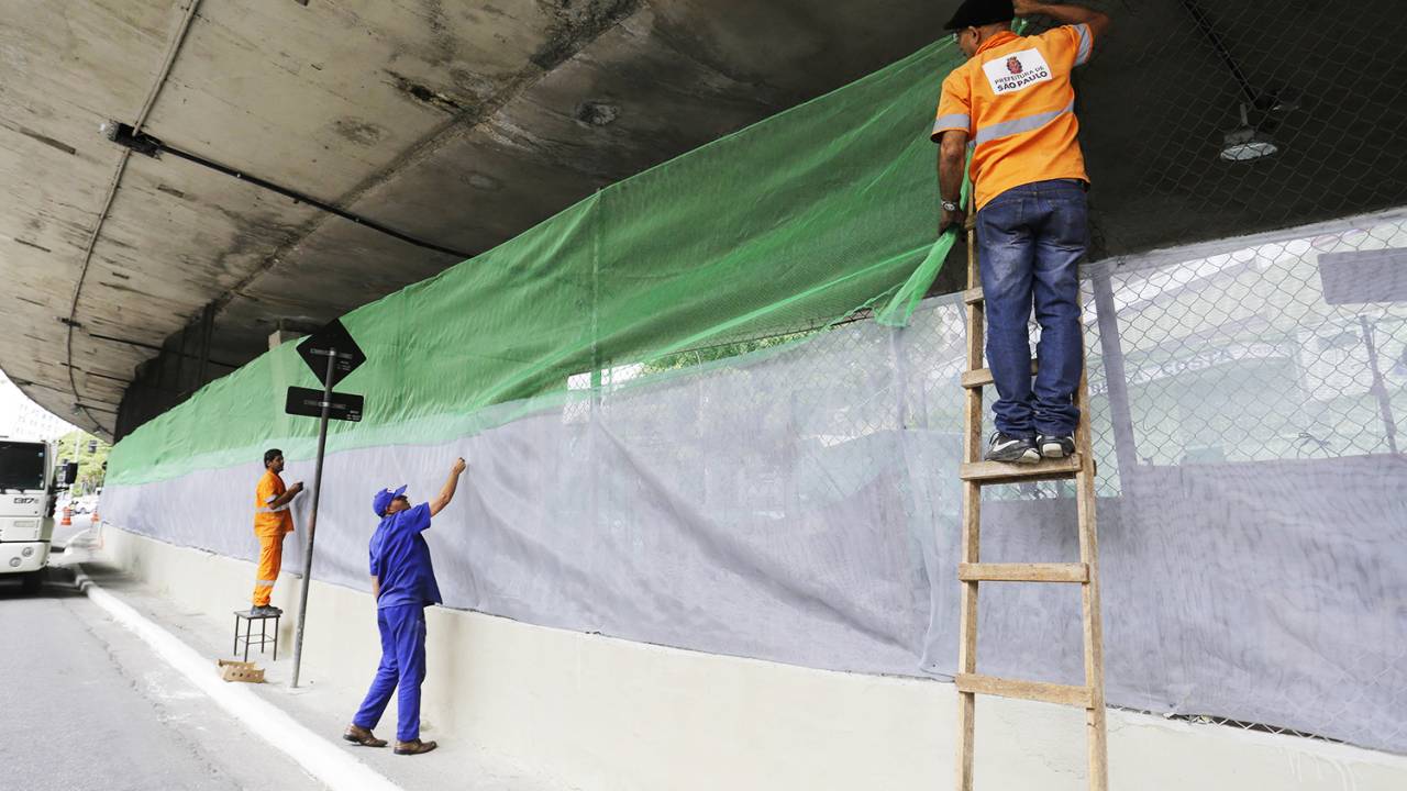 Funcionários da Prefeitura instalam telas em volta do viaduto Doutor Plínio de Queiroz, na avenida Nove de Julho, em São Paulo (SP), onde estão moradores de rua que vivem no local - 06/01/2017