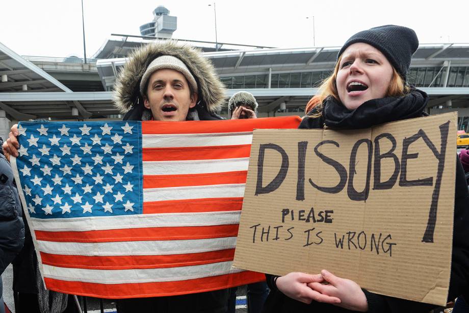 Manifestantes protestam no lado de fora do Terminal 4 do Aeroporto Internacional John F. Kennedy, contra o decreto do presidente Donald Trump para barrar a entrada de cidadãos de sete países muçulmanos nos Estados Unidos  - 28/01/2017