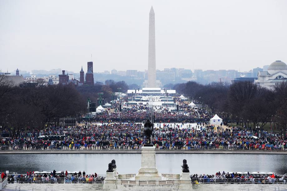 Pessoas começam a chegar para a cerimônia de posse de Donald Trump diante do Monumento de Washington enquanto parte da cidade é iluminada pelo sol no amanhecer