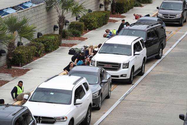 Pessoas se escondem atrás de carros estacionados após atirador matar cinco no aeroporto internacional de Fort Lauderdale, na Flórida - 06/01/2017 Pessoas se escondem atrás de carros estacionados após atirador matar cinco no aeroporto internacional de Fort Lauderdale, na Flórida - 06/01/2017