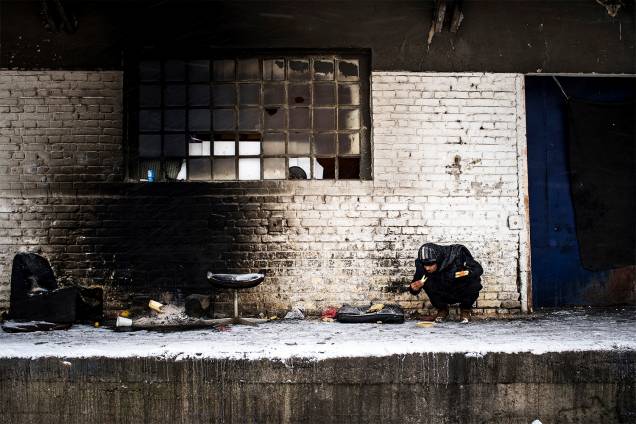 Migrante se alimenta em um armazém abandonado de Belgrado, na Sérvia - 11/01/2017 Migrante se alimenta em um armazém abandonado de Belgrado, na Sérvia - 11/01/2017