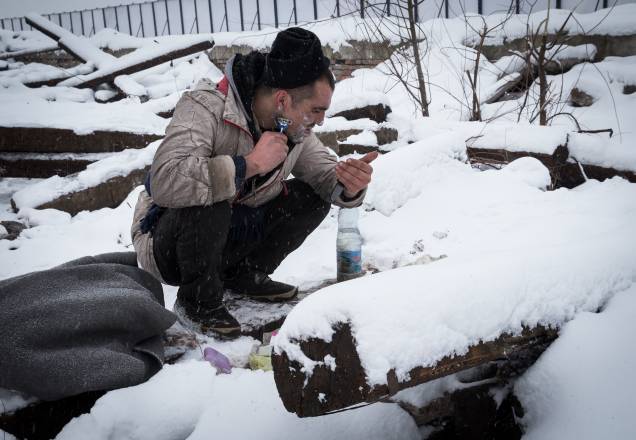 Imigrante faz a barba cercado de neve em Belgrado, Sérvia Imigrante faz a barba cercado de neve em Belgrado, Sérvia
