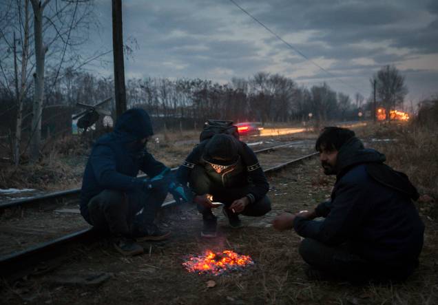 Imigrantes se aquecem em volta de uma fogueira, para se protegerem das temperaturas de menos 20 graus celsius, em Belgrado, Sérvia Imigrantes se aquecem em volta de uma fogueira, para se protegerem das temperaturas de menos 20 graus celsius, em Belgrado, Sérvia