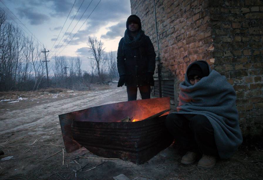 Imigrantes se aquecem em volta de uma fogueira, para se protegerem das temperaturas de menos 20 graus celsius, em Belgrado, Sérvia