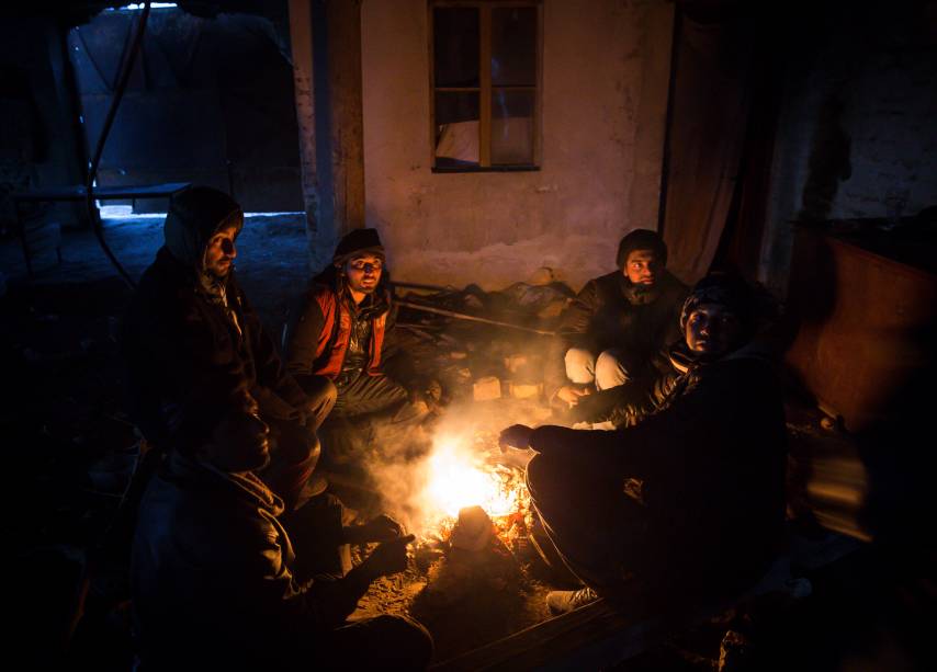 Imigrantes se aquecem em volta de uma fogueira, para se protegerem das temperaturas de menos 20 graus celsius, em Belgrado, Sérvia