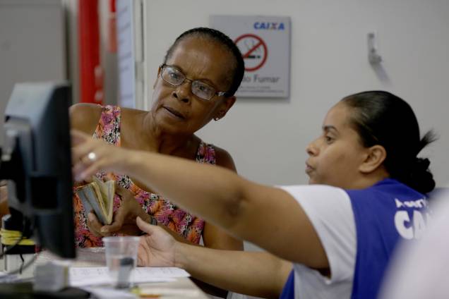 Pessoas se dirigem as agências da Caixa Econômica Federal para obter informações sobre FGTS Pessoas se dirigem as agências da Caixa Econômica Federal para obter informações sobre FGTS