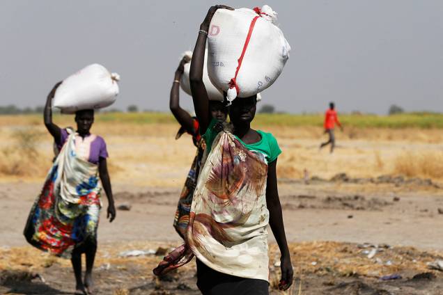 Mulher carrega saco com alimento despejado pelo avião da ONU no vilarejo de Nimini, no Sudão do Sul Mulher carrega saco com alimento despejado pelo avião da ONU no vilarejo de Nimini, no Sudão do Sul