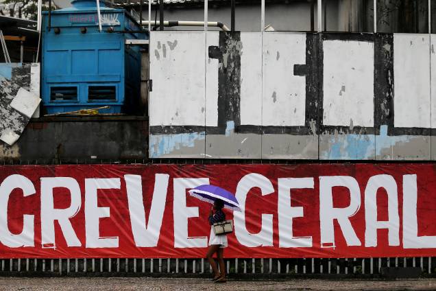 Mulher passa por uma faixa escrita 'Greve Geral' durante dia de manifestações contrárias às reformas propostas pelo governo Michel Temer no Rio de Janeiro - 28/04/2017 Mulher passa por uma faixa escrita 'Greve Geral' durante dia de manifestações contrárias às reformas propostas pelo governo Michel Temer no Rio de Janeiro - 28/04/2017
