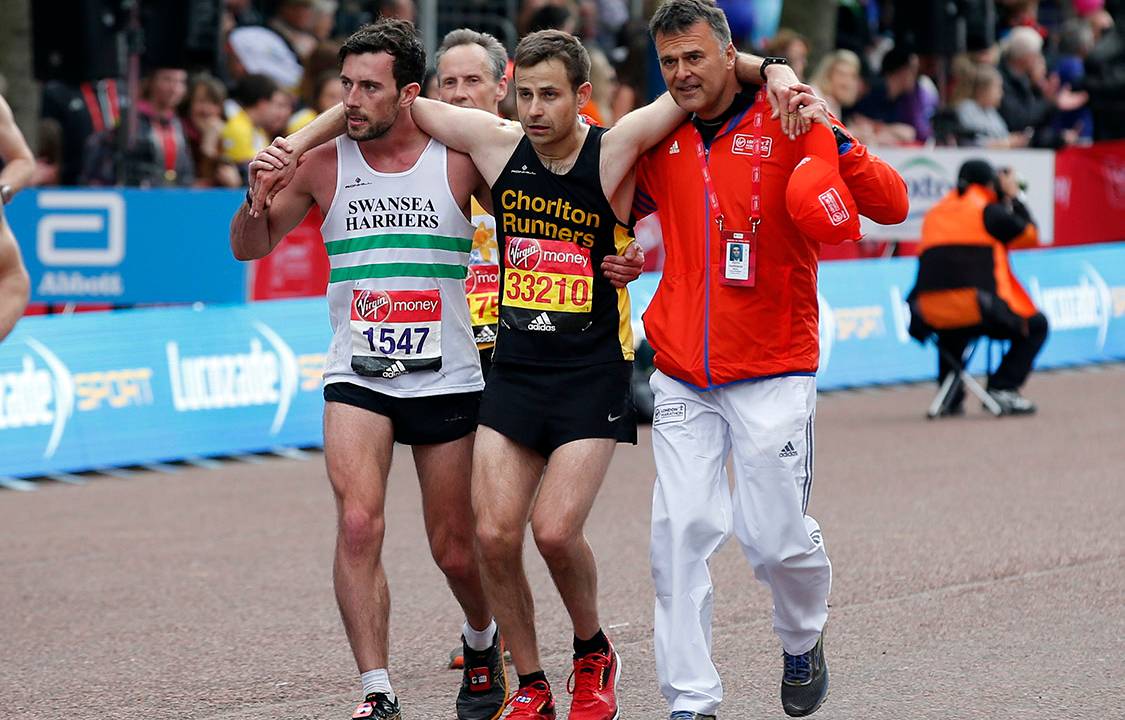 Britain Athletics - London Marathon - London - 23/4/17 Matthew Rees of Swansea Harrier (L) helping an ailing David Wyeth of Chorlton Runners (C) down The Mall to finish the Virgin Money London Marathon Action Images via Reuters / Matthew Childs Livepic