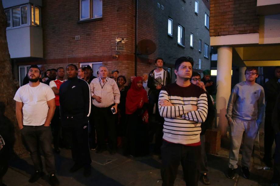 Moradores do bairro assistem os 27 andares do Grenfell Tower, em Londres pegando fogo enquanto policiais e bombeiros tentam evacuar o local - 14/06/2017