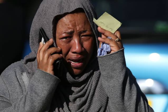 Ao telefone, uma mulher chora desesperada na tentativa de localizar um parente desaparecido e que teria sido afetado pelas chamas do Grenfell Tower, no oeste de Londres - 14/06/2017 Ao telefone, uma mulher chora desesperada na tentativa de localizar um parente desaparecido e que teria sido afetado pelas chamas do Grenfell Tower, no oeste de Londres - 14/06/2017