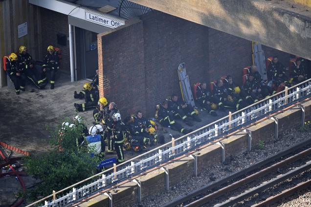 Após o assolador incêndio no Grenfell Tower, bombeiros sentam-se à sombra para descansar - 17/06/2017 Após o assolador incêndio no Grenfell Tower, bombeiros sentam-se à sombra para descansar - 17/06/2017