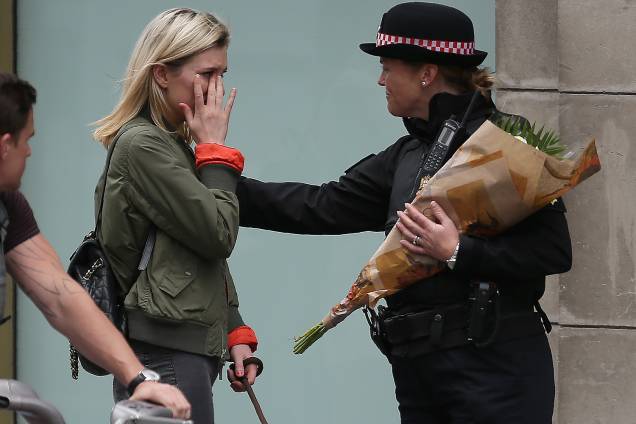 Mulher chora ao levar flores ao local do atentado na London Bridge - 04/06/2017 Mulher chora ao levar flores ao local do atentado na London Bridge - 04/06/2017