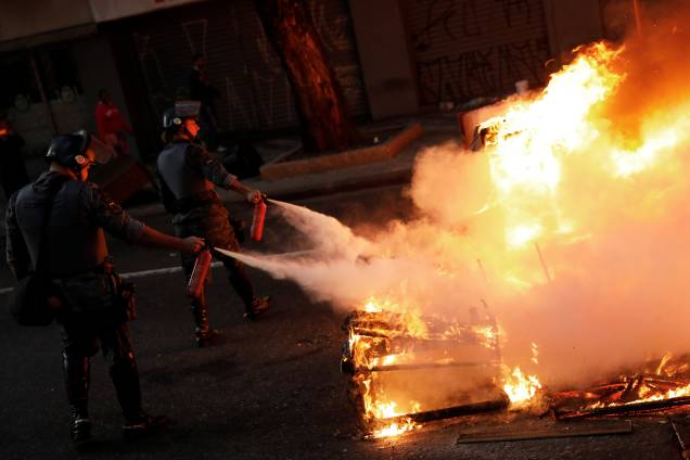 Policiais apagam barricada em chamas feita por manifestantes durante protesto contra as reformas econômicas propostas pelo presidente Michel Temer nesta manhã em São Paulo. Policiais apagam barricada em chamas feita por manifestantes durante protesto contra as reformas econômicas propostas pelo presidente Michel Temer nesta manhã em São Paulo.