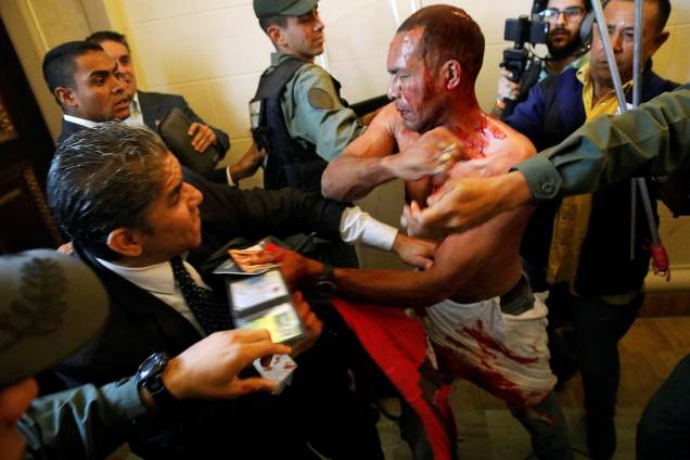 Homem coberto de sangue tenta deixar a Assembleia Nacional da Venezuela, após um grupo de apoiadores do governo de Nicolas Maduro invadiram a sede do Legislativo, controlada pela oposição, em protesto durante uma sessão parlamentar - 05/07/2017 Homem coberto de sangue tenta deixar a Assembleia Nacional da Venezuela, após um grupo de apoiadores do governo de Nicolas Maduro invadiram a sede do Legislativo, controlada pela oposição, em protesto durante uma sessão parlamentar - 05/07/2017