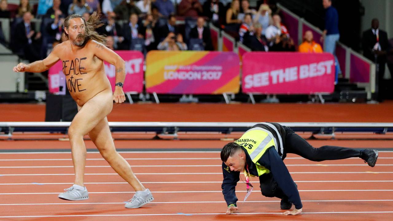 Seguranças tentam conter manifestante que invadiu o estádio nu durante prova do Mundial de Atletismo