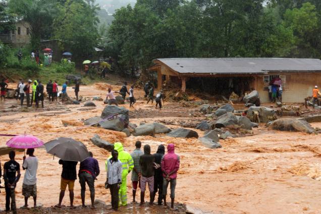 Pessoas observam a lama de um deslizamento de terra que atingiu a capital da África Ocidental, Serra Leoa. Pelo menos 312 pessoas foram mortas e mais de 2.000 perderam suas casas quando as grandes inundações atingiram a cidade de Freetown - 14/08/2017 Pessoas observam a lama de um deslizamento de terra que atingiu a capital da África Ocidental, Serra Leoa. Pelo menos 312 pessoas foram mortas e mais de 2.000 perderam suas casas quando as grandes inundações atingiram a cidade de Freetown - 14/08/2017