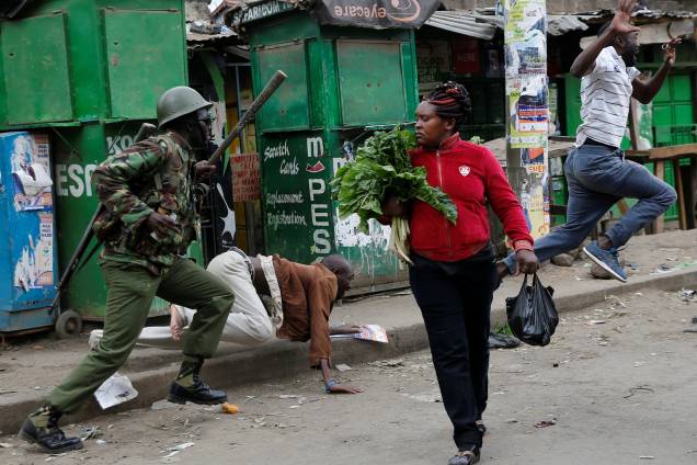 Policiais tentam dispersar manifestantes durante protesto contra o resultado das eleições no Quênia, enquanto uma mulher passa com seus vegetais pelas ruas da favela de Mathare, em Nairobi Policiais tentam dispersar manifestantes durante protesto contra o resultado das eleições no Quênia, enquanto uma mulher passa com seus vegetais pelas ruas da favela de Mathare, em Nairobi