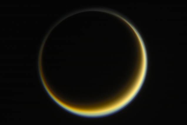 Cassini fotografa face escura de Titã, a maior lua de Saturno, enquanto o Sol ilumina o outro lado. É possível observar a névoa alaranjada que existe na atmosfera do astro. Cassini fotografa face escura de Titã, a maior lua de Saturno, enquanto o Sol ilumina o outro lado. É possível observar a névoa alaranjada que existe na atmosfera do astro.