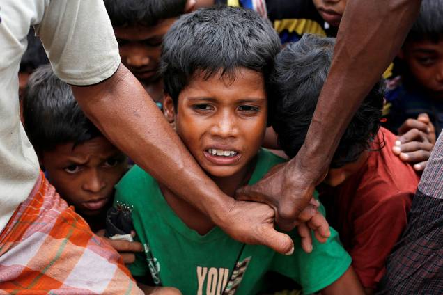 Crianças refugiadas aguardam para receberem comida distribuída por uma ONG local, em BangladeshMulçumanos rohyngias sentam em frente a uma fogueira, em um acampamento para refugiados, em Bangladesh - 09/09/2017 Crianças refugiadas aguardam para receberem comida distribuída por uma ONG local, em BangladeshMulçumanos rohyngias sentam em frente a uma fogueira, em um acampamento para refugiados, em Bangladesh - 09/09/2017