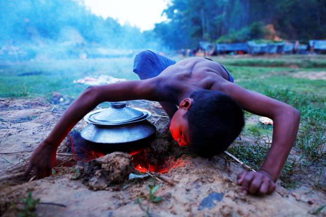 Criança refugiada acende fogo para cozinhar uma refeição, próximo ao seu abrigo temporário - 12/09/2017 Criança refugiada acende fogo para cozinhar uma refeição, próximo ao seu abrigo temporário - 12/09/2017