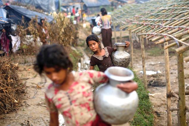 Crianças rohingyas carregam vasos com água em um campo de refugiados, em Bangladesh - 13/09/2017 Crianças rohingyas carregam vasos com água em um campo de refugiados, em Bangladesh - 13/09/2017