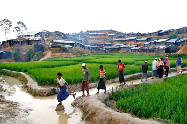 Mulçumanos rohingyas caminham sobre um canal em um campo de refugiados, em Bangladesh - 13/09/2017 Mulçumanos rohingyas caminham sobre um canal em um campo de refugiados, em Bangladesh - 13/09/2017