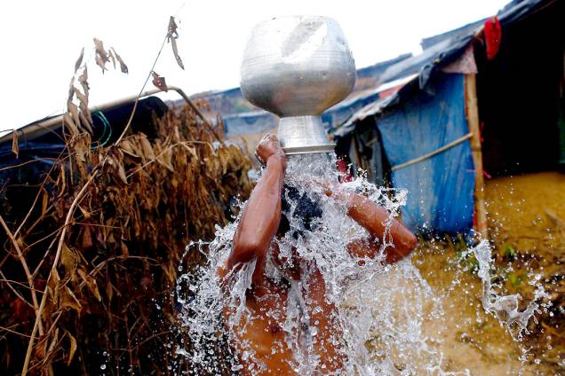 Homem rohingya toma banho ao lado de fora de seu abrigo, em um campo de refugiados em Bangladesh - 13/09/2017 Homem rohingya toma banho ao lado de fora de seu abrigo, em um campo de refugiados em Bangladesh - 13/09/2017