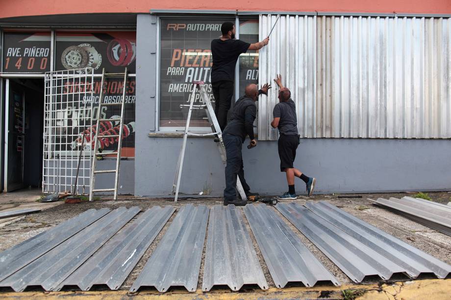 Homens protegem janelas com placas para a chegada do Furacão Irma, em San Juan, Porto Rico