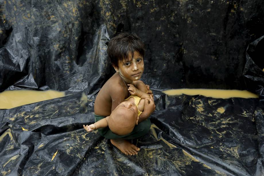 Um refugiado rohingya recém chegado à Bangladesh segura um bebê nos braços em um campo para refugiados na cidade de Teknaf, perto da fronteira com Myanmar. Segundo a ONU, 123.600 pessoas atravessaram a fronteira nos últimos 11 dias do estado de Rakhine, devido a violência em Myanmar - 05/09/2017