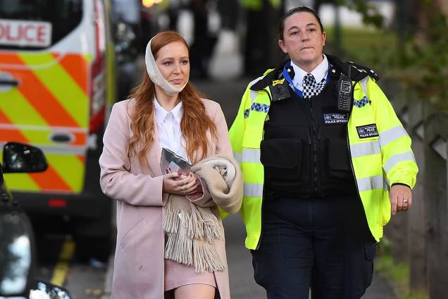 Policial acompanha uma mulher ferida após uma bomba caseira explodir dentro do vagão de um trem na Estação Parsons Green, da District Line, conhecida como “linha verde” em Londres. A polícia trata o caso como terrorismo - 15/09/2017 Policial acompanha uma mulher ferida após uma bomba caseira explodir dentro do vagão de um trem na Estação Parsons Green, da District Line, conhecida como “linha verde” em Londres. A polícia trata o caso como terrorismo - 15/09/2017