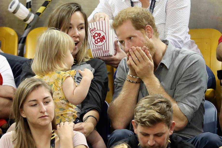 Hayley Henson e a filha Emily Henson sentam-se com o Príncipe Harry para comer pipoca e assistir às finais do vôlei durante os Jogos Invictus 2017 no Centro de Atletismo Mattamy, em Toronto, no Canadá